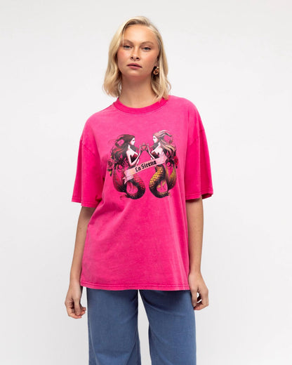 Make waves in the La Sirena Tee in pink. Designed in a relaxed, oversized fit with a soft vintage wash, this tee showcases the striking twin mermaid “La Sirena” graphic across the front. Effortlessly bold yet laid-back, it’s the perfect piece to add a splash of ocean-inspired charm to your everyday wardrobe.