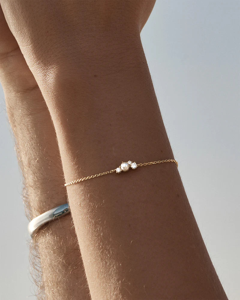 The Love in Stillness Pearl Bracelet celebrate those unseen moments - when we close our eyes to feel deeper, to connect beyond sight with love, with memory, with presence. This keepsake is an expression of romance in its softness and stillness.&nbsp;

18k Gold Vermeil: 2.5 microns of 18 carat gold coating a sterling silver base.&nbsp;

Delicate pearl cluster design.&nbsp;

Set with a round freshwater pearl and cubic zirconias in a claw setting.&nbsp;

Bracelet length: 19cm.&nbsp;

Features a silicon ball sl