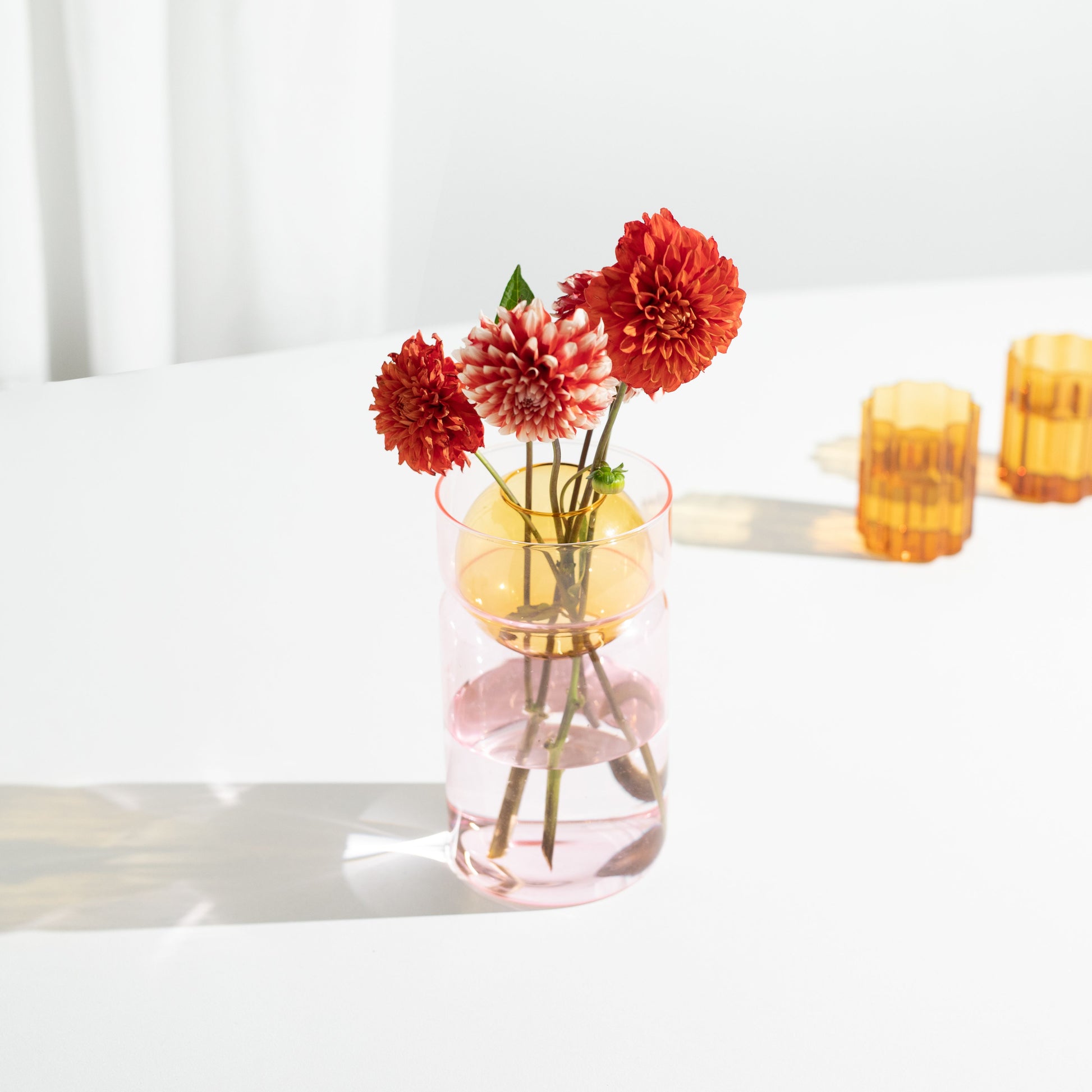 These playful cylindrical vases feature an internal sphere with two hand-cut holes ready to be filled with freshly picked flowers and foliage or to grace any space as a decorative sculptural piece.
