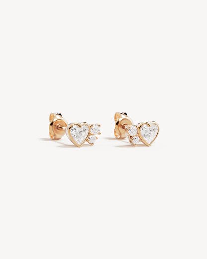 The Dream Lover Heart Stud Earrings speaks to the unspoken connections and the in-between moments of utmost intimacy. The delicate heart cluster design encapsulates the dreamy moments of tender love and connections we hold closest to our hearts.&nbsp;

18k Gold Vermeil: 2.5 microns of 18 carat gold coating a sterling silver base.&nbsp;

Features heart (bezel setting) and round (claw) cut cubic zirconias.&nbsp;

Sold as a pair.&nbsp;

Size: 7 x 5mm.&nbsp;

Polished finish.&nbsp;