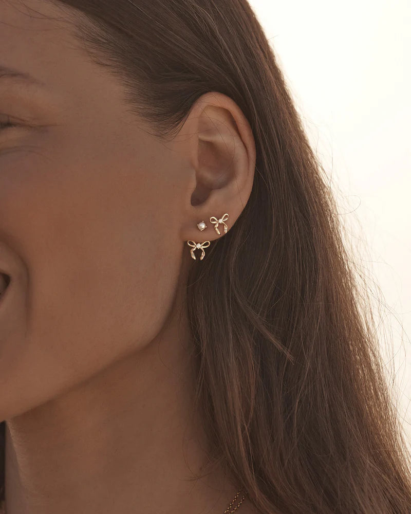 By Charlotte - The Forever More Bow Stud Earrings are a playful and delicate ode to love and romance. This keepsake is a tangible expression of the saying "tied together", with the bows symbolising love, cherished bonds, and devotion.&nbsp;

18k Gold Vermeil: 2.5 microns of 18 carat gold coating a sterling silver base.&nbsp;

Delicate bow design set with a sparkling cubic zirconia.&nbsp;

Sold as a pair.&nbsp;

9 x 8mm.&nbsp;

Polished finish.&nbsp;