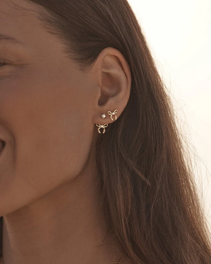 By Charlotte - The Forever More Bow Ear Jacket are a playful and delicate ode to love and romance. This keepsake is a tangible expression of the saying "tied together", with the bows symbolising love, cherished bonds, and devotion.&nbsp;

18k Gold Vermeil: 2.5 microns of 18 carat gold coating a sterling silver base.&nbsp;

Ear jacket design. &nbsp;

Length is adjustable allowing for a seamless fit.&nbsp;

Creates a floating pendant effect against your ear.&nbsp;

Design can be worn as a solo stud - simply r