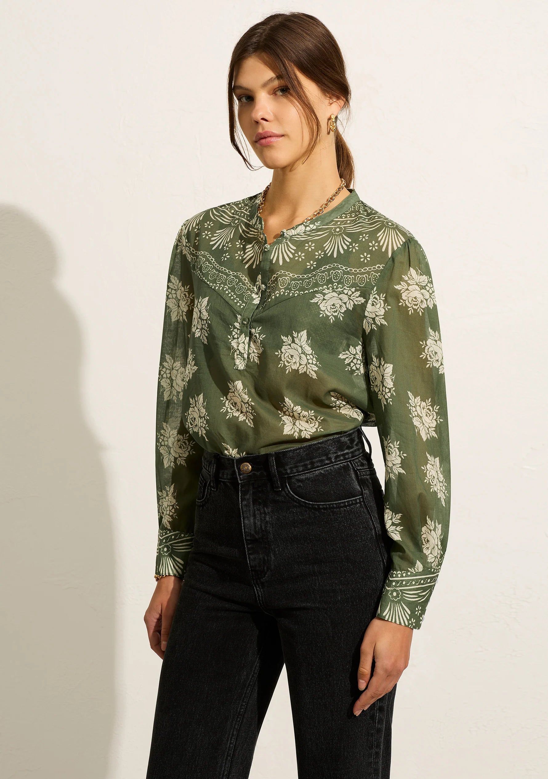 The Elsa Blouse is crafted from subtly sheer cotton in our green Mabel floral. This style offers a Henley neckline with a half-button front closure, long sleeves with a traditional shirting cuff and shaped western yoke detailing.