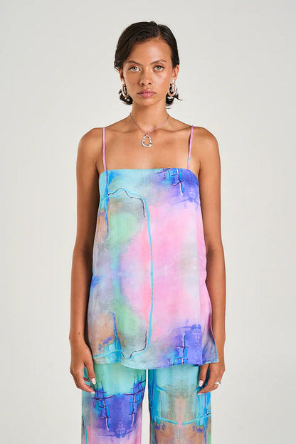 The Tunic Top showcasing the hand-painted H20 print has been crafted from a silky viscose/ rayon blend and boasts a straight cut bodice, adjustable straps, and a flowing body with side slits for style and functionality.
