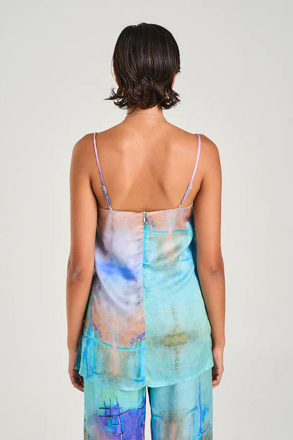 The Tunic Top showcasing the hand-painted H20 print has been crafted from a silky viscose/ rayon blend and boasts a straight cut bodice, adjustable straps, and a flowing body with side slits for style and functionality.
