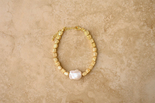 The Agnes Gold and Pearl Bracelet is by Indigo and Wolfe

Get ready to make a statement with AGNES Bracelet

With its unique crushed gold vermeil and stunning baroque pearl, this piece will add boldness and beauty to any outfit

Plus, it's lead, nickel, and tarnish-free, making it hypoallergenic for all to wear

Be bold, be beautiful, be AGNES

24Kt Crushed Gold Vermeil
Pure Baroque Pearl
Lead,Nickel &amp; Tarnish Free
Hypoallergenic

Waterproof and Tarnish free

Lightweight

Avoid contact with perfume