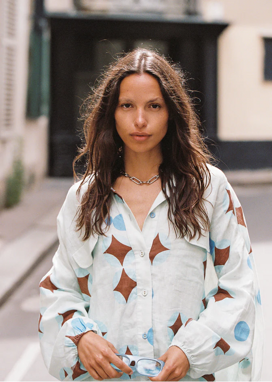 Aquarius Chalm shirt - A relaxed airy shirt perfect for roaming unchartered European streets and dancing in the dark. A unique brown celestial print features on soft baby blue linen trims. It’s floaty, effortless, and just the right amount of whimsical. Style it buttoned-up or layered loose!