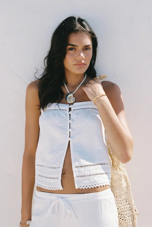 The Macy Scallop Top is the ultimate blend of effortless femininity and coastal charm. Crafted from lightweight cotton with a softly textured finish, this breezy top features delicate scalloped hems and intricate ladder lace detailing that elevate its simple silhouette.