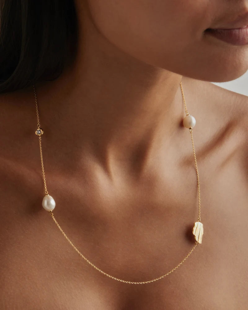 Our&nbsp;18k Gold Vermeil Moonlit Tides Necklace&nbsp;honours the relationship between the divine moon and the ocean.&nbsp;Set with a sparkling&nbsp;crystal&nbsp;and baroque freshwater pearls, this necklace can be worn wrapped around twice for a double layered necklace look.&nbsp;Just as the&nbsp;moon rules the tides of the sea,&nbsp;feel inspired to embrace&nbsp;your&nbsp;divine power.&nbsp;&nbsp;