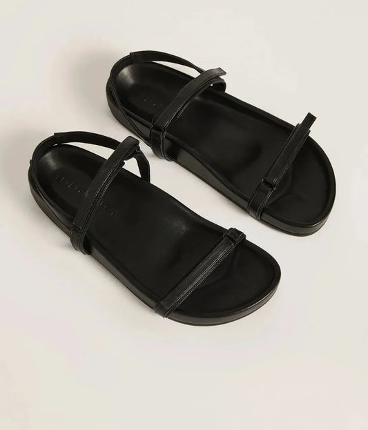 The Thin Strap Sandal by Nude Lucy. Made from premium 100% sheep leather upper grounded on a solid rubber base. The sole is made with soft arched shaping for extra support and comfort. This Black Strappy Sandal features adjustable thin straps and a moulded foot bed.