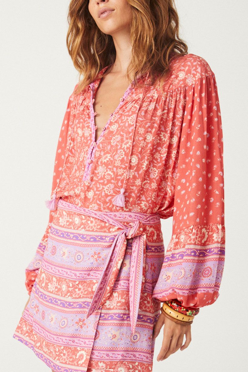 The SPELL Sunshine Bandit Blouse in Cayenne is crafted for the wild romantics. Our blouse is incredibly flattering, featuring a drawstring tie hem that can be left loose with the hem skimming the hips or pulled to the waist for a cropped option. Our blouse is elevated with neck ties and drawstring hem ties including handmade tassels, billowing sleeves and elegant gathers at the yoke. 