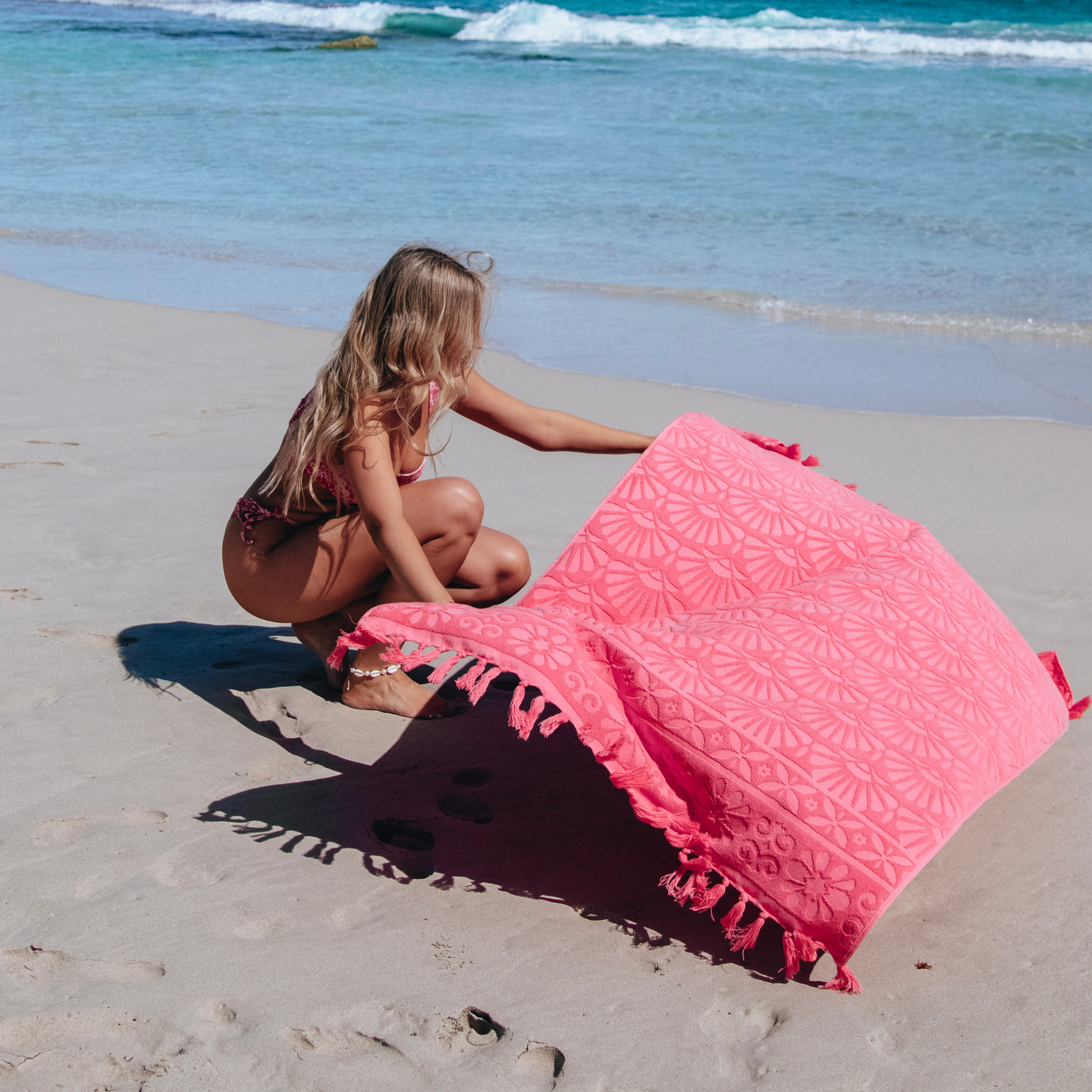 Isla in Bloom Lucia Hot Pink Beach Towel Model Laying it on the beach