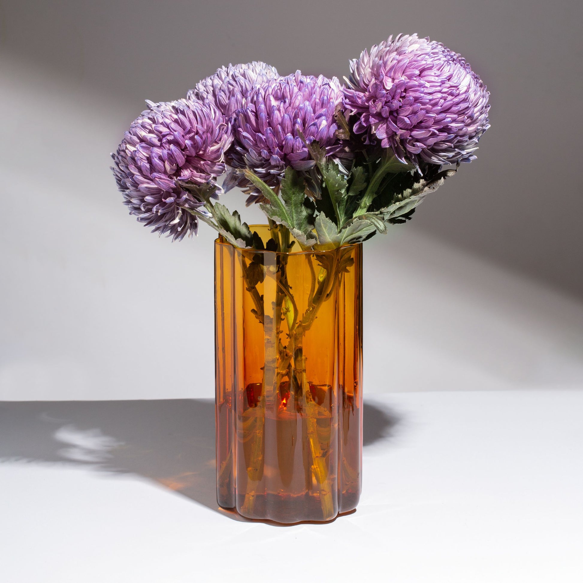 FAZEEK’s Wave Vase - Amber is finely crafted from hand-blown coloured glass and features our signature rippled edge. Beautiful in its simplicity, the Wave Vase will complement any space.