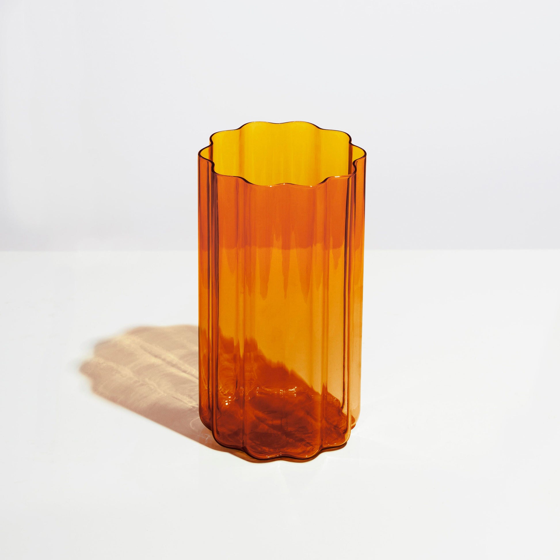 FAZEEK’s Wave Vase - Amber is finely crafted from hand-blown coloured glass and features our signature rippled edge. Beautiful in its simplicity, the Wave Vase will complement any space.